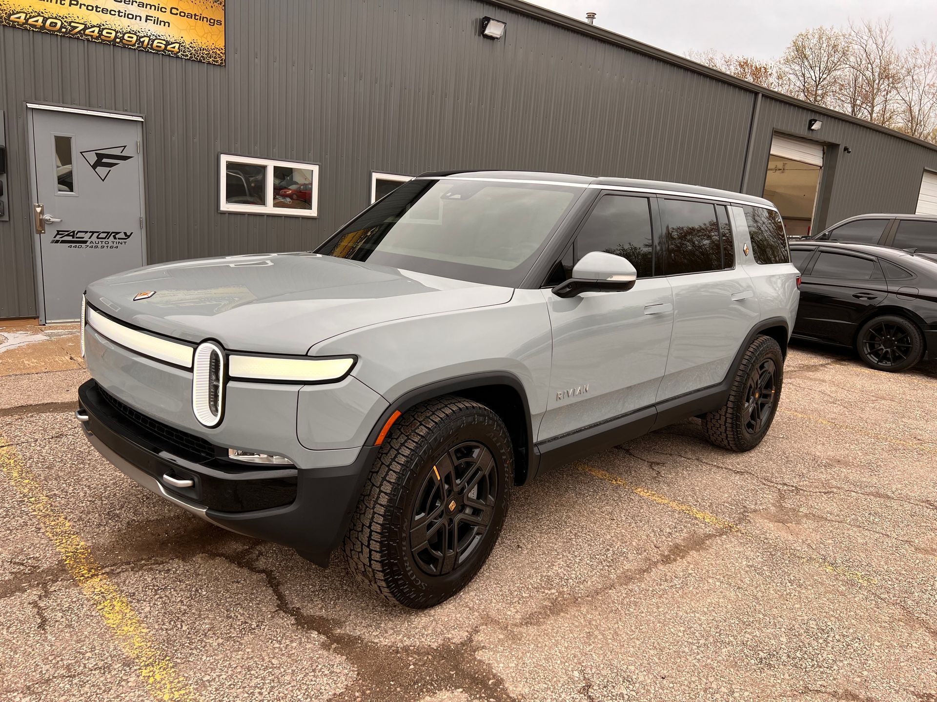 A gray suv is parked in front of a building.
