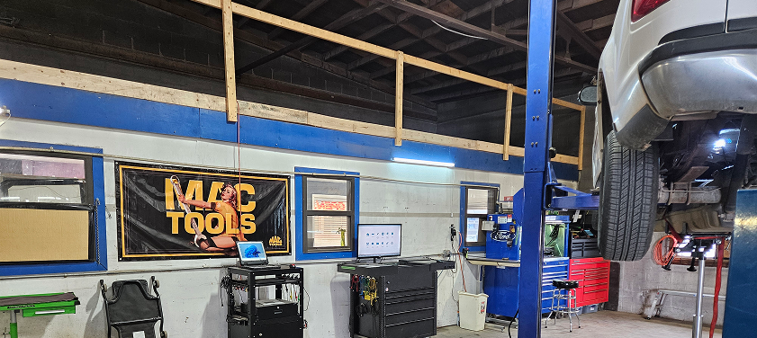 A car is sitting on a lift in a garage. | J & J Automotive
