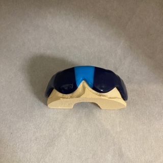 A blue and white mouth guard is sitting on a white surface.