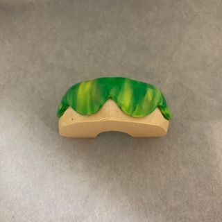 A green and yellow mouth guard is sitting on a table.