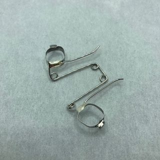 A pair of metal rings are sitting on a white surface.