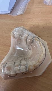 A dental retainer is sitting on top of a wooden table.