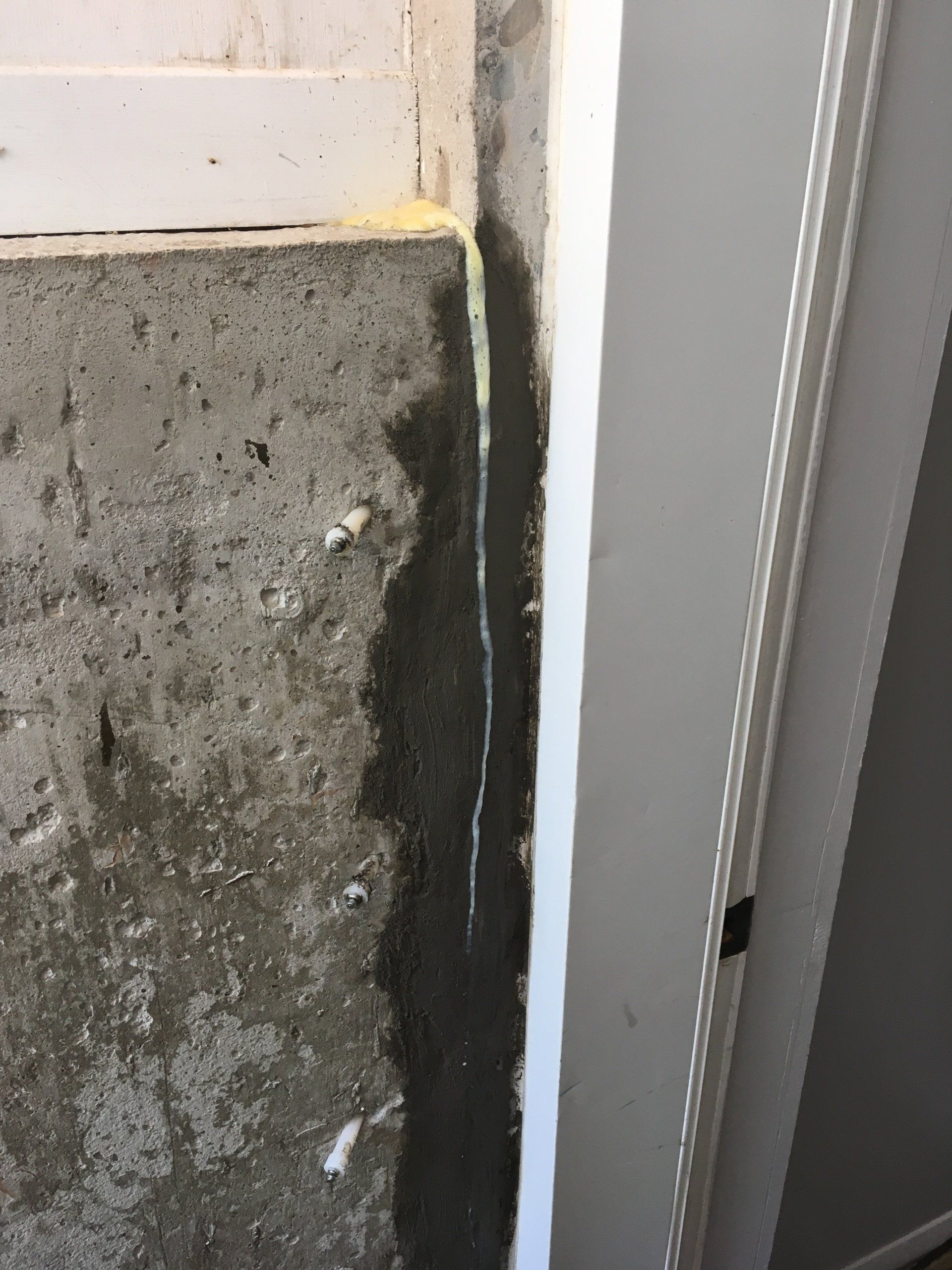 Un coin d'un mur en béton avec une garniture blanche.