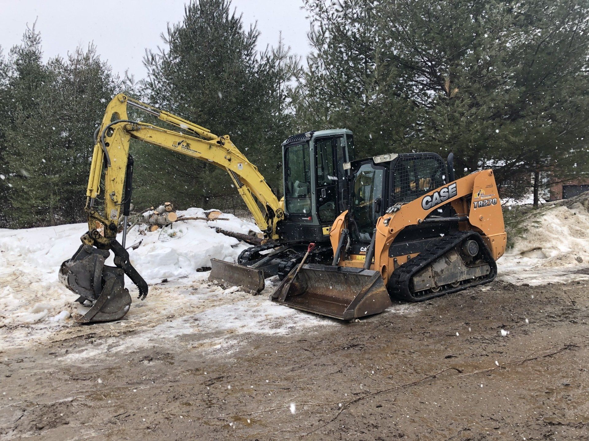 Un bulldozer et une excavatrice sont garés dans un champ enneigé.