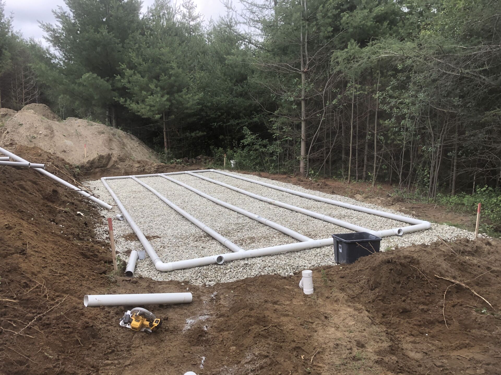 Une fosse septique est en cours de construction au milieu d'une forêt.