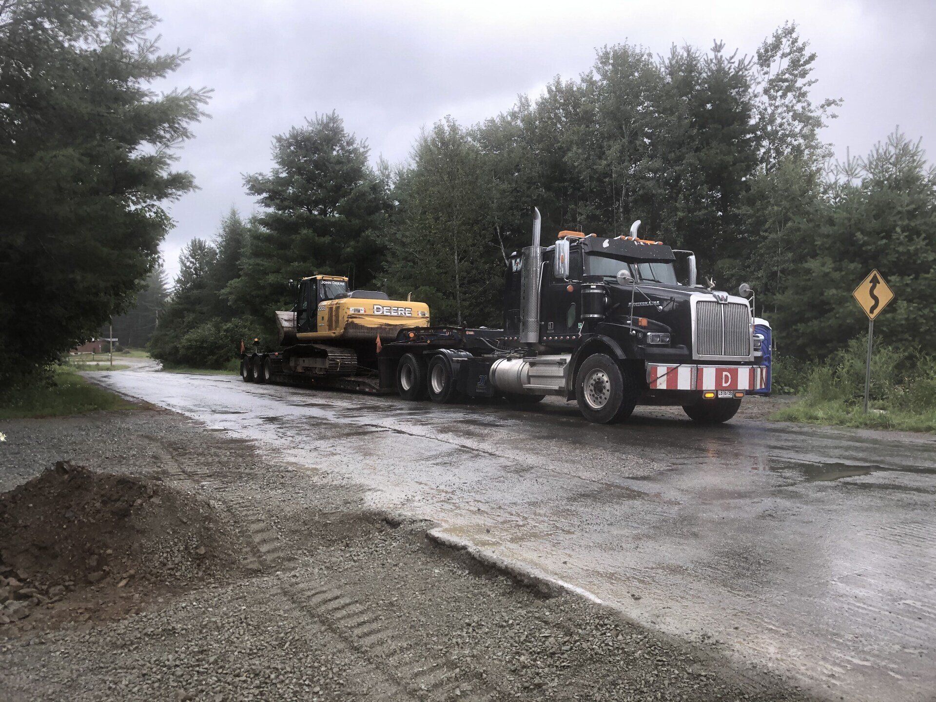 Un camion avec une excavatrice jaune à l'arrière