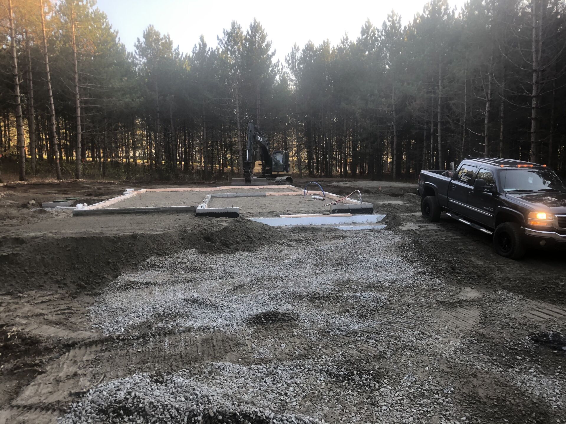 Un camion est garé dans un champ de terre au milieu d'une forêt.