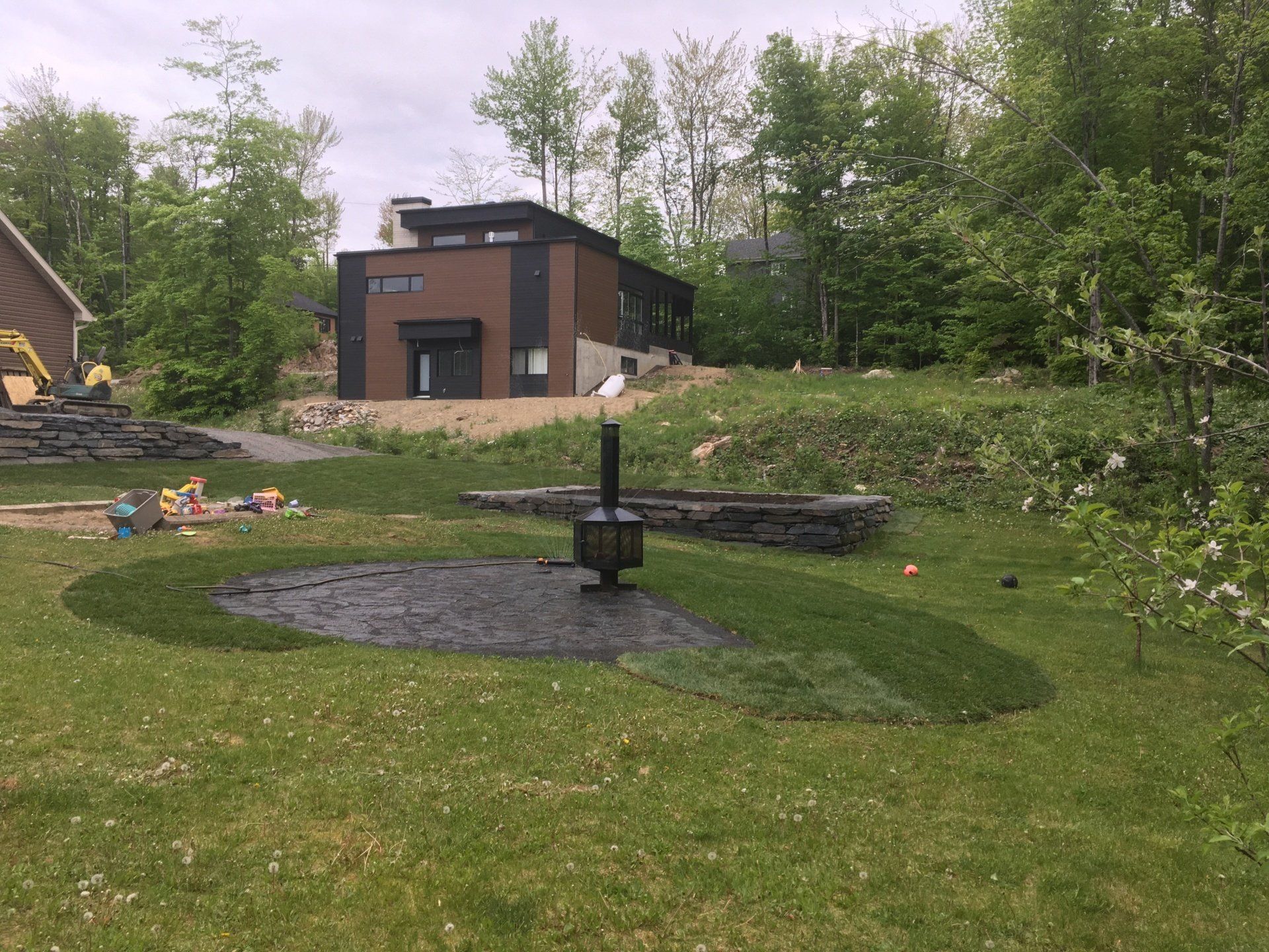 Une cour arrière avec un foyer et une maison en arrière-plan.