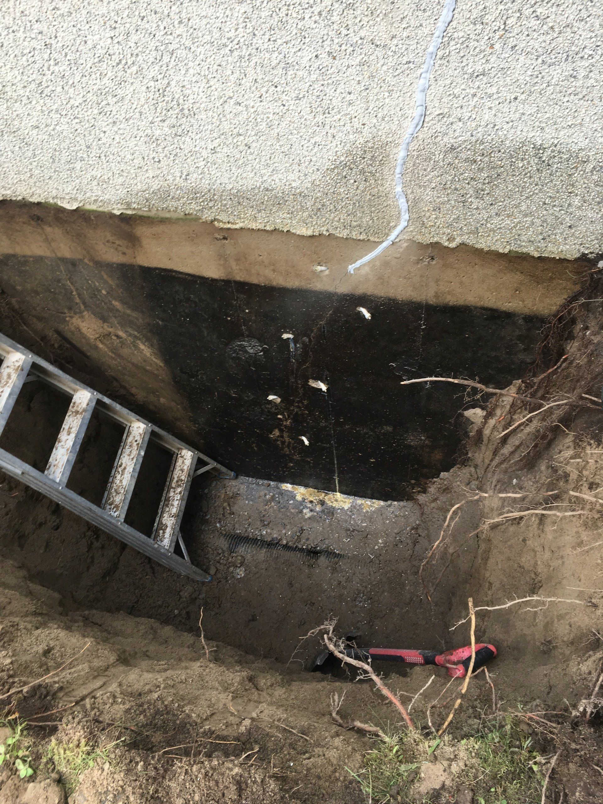 Une échelle sort d'un trou dans le sol.