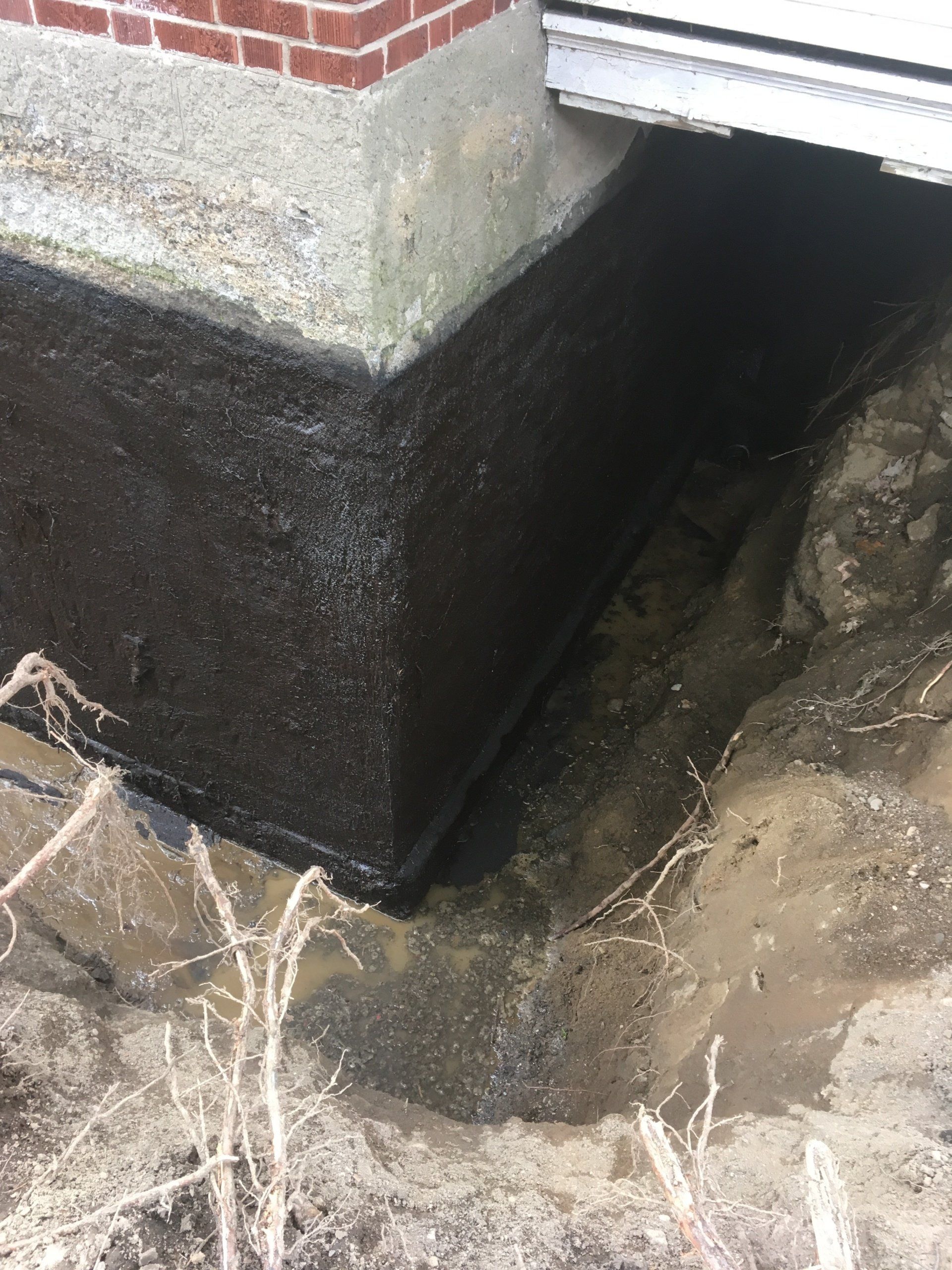 Un mur de briques avec un trou dans le sol en dessous.
