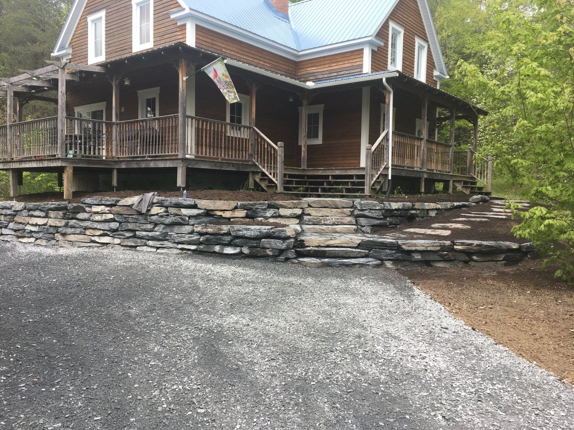 Une grande maison en bois avec un toit bleu et un grand porche