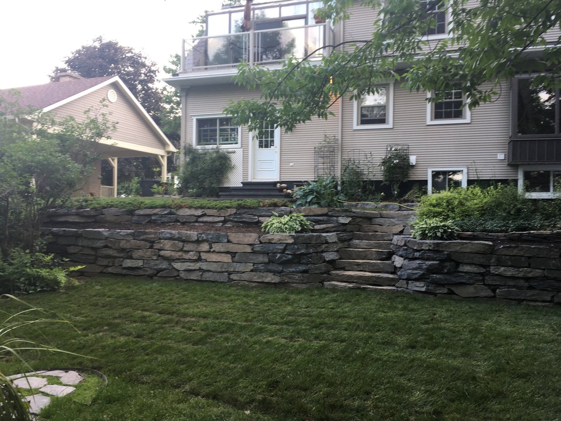 Une maison avec un mur de pierre devant elle