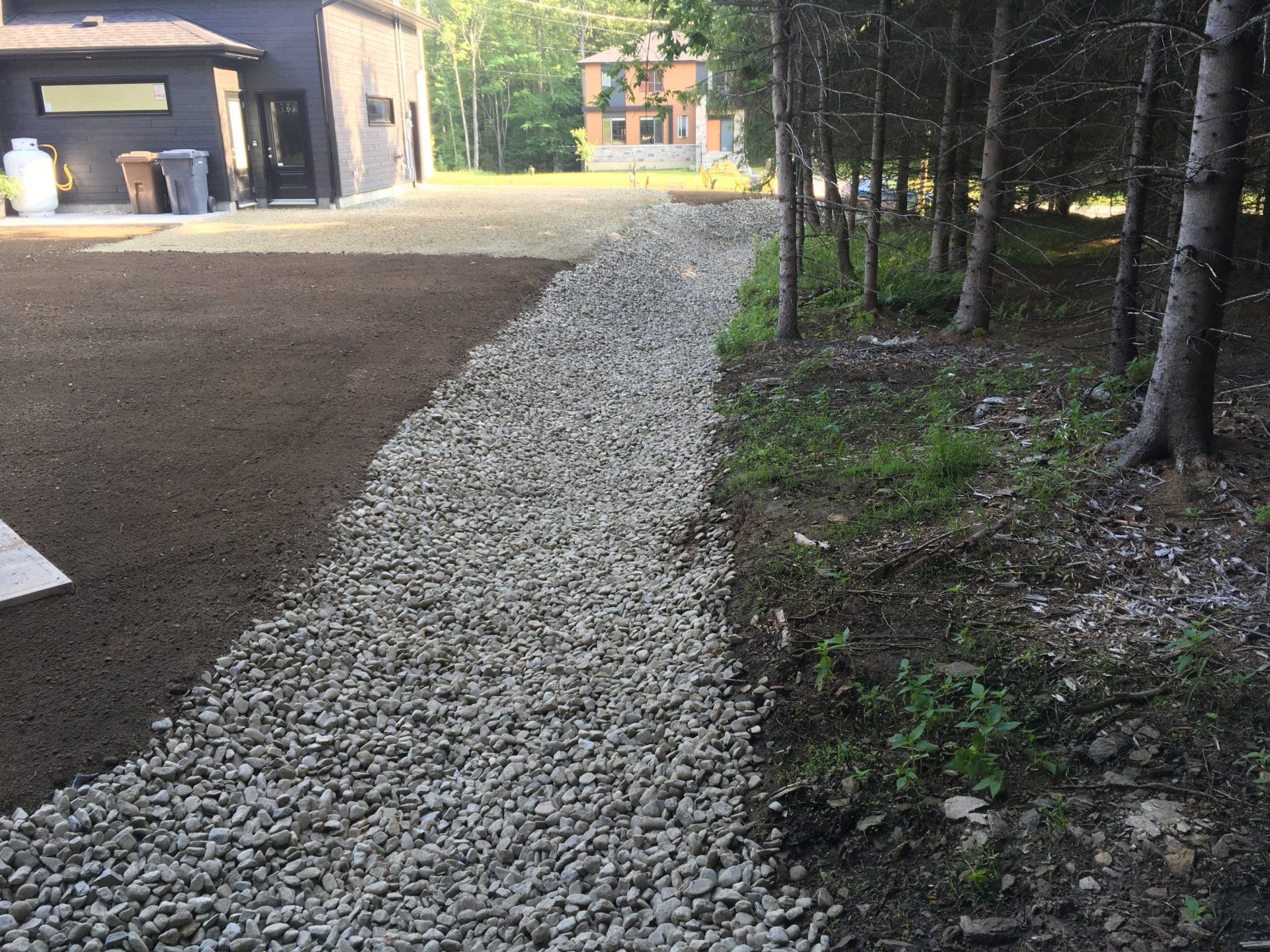 Un chemin de gravier menant à une maison dans les bois