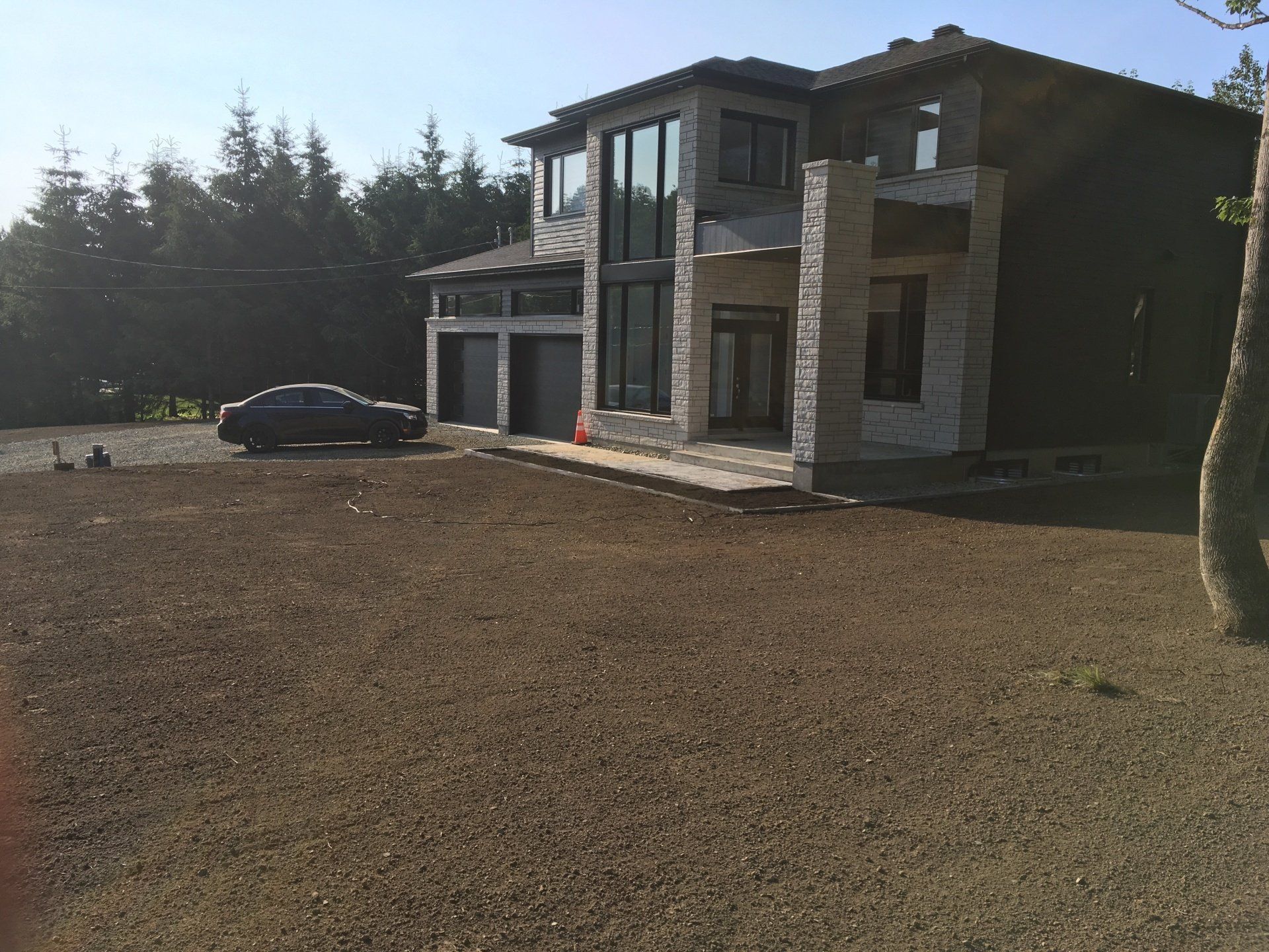 Une grande maison avec une voiture garée devant.
