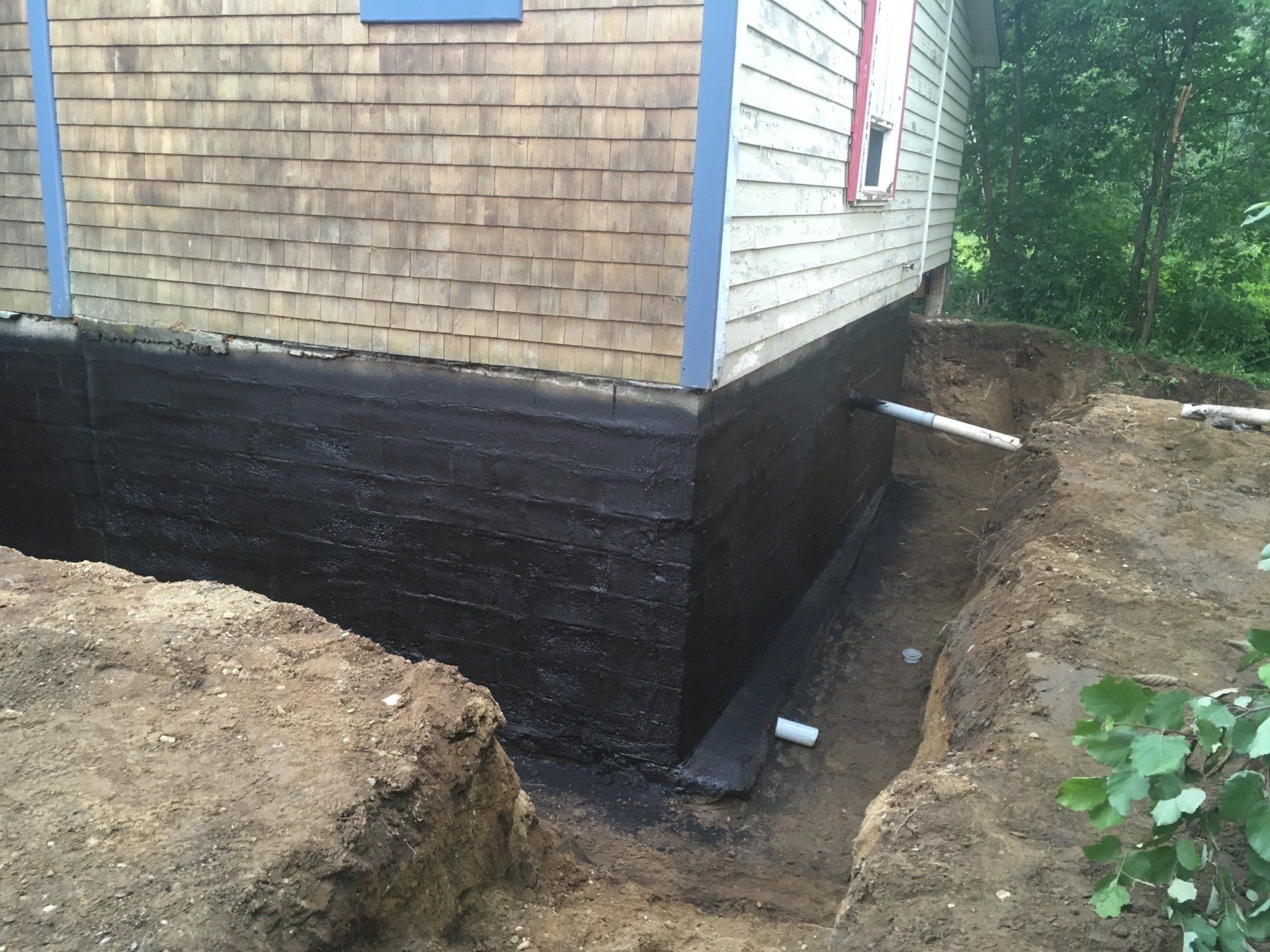 Les fondations d'une maison sont imperméabilisées avec de la peinture noire.