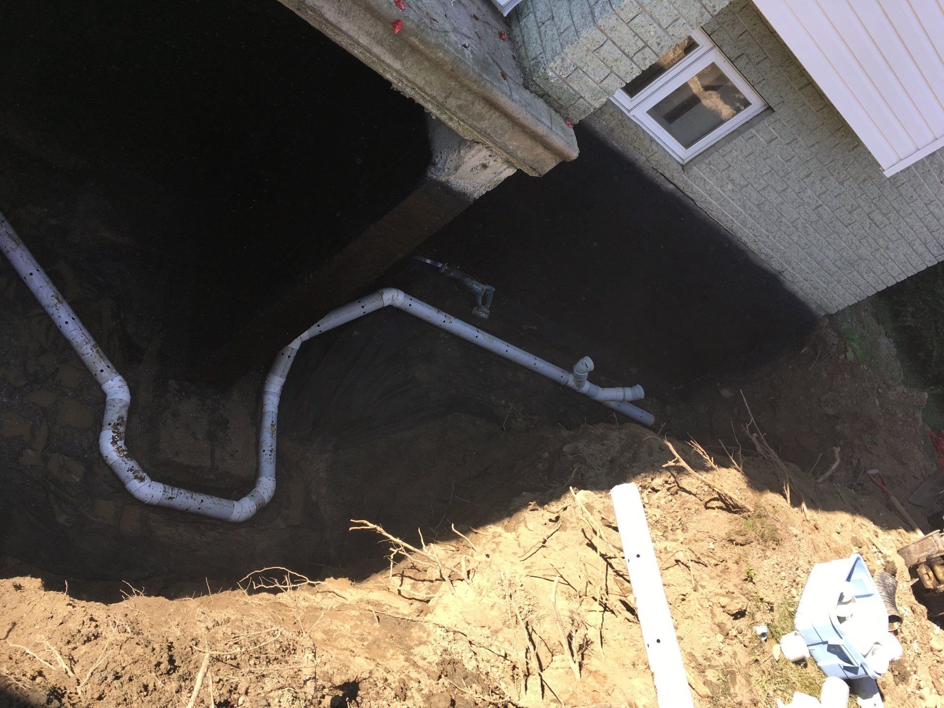 Un tas de tuyaux sortent du sol devant une maison.