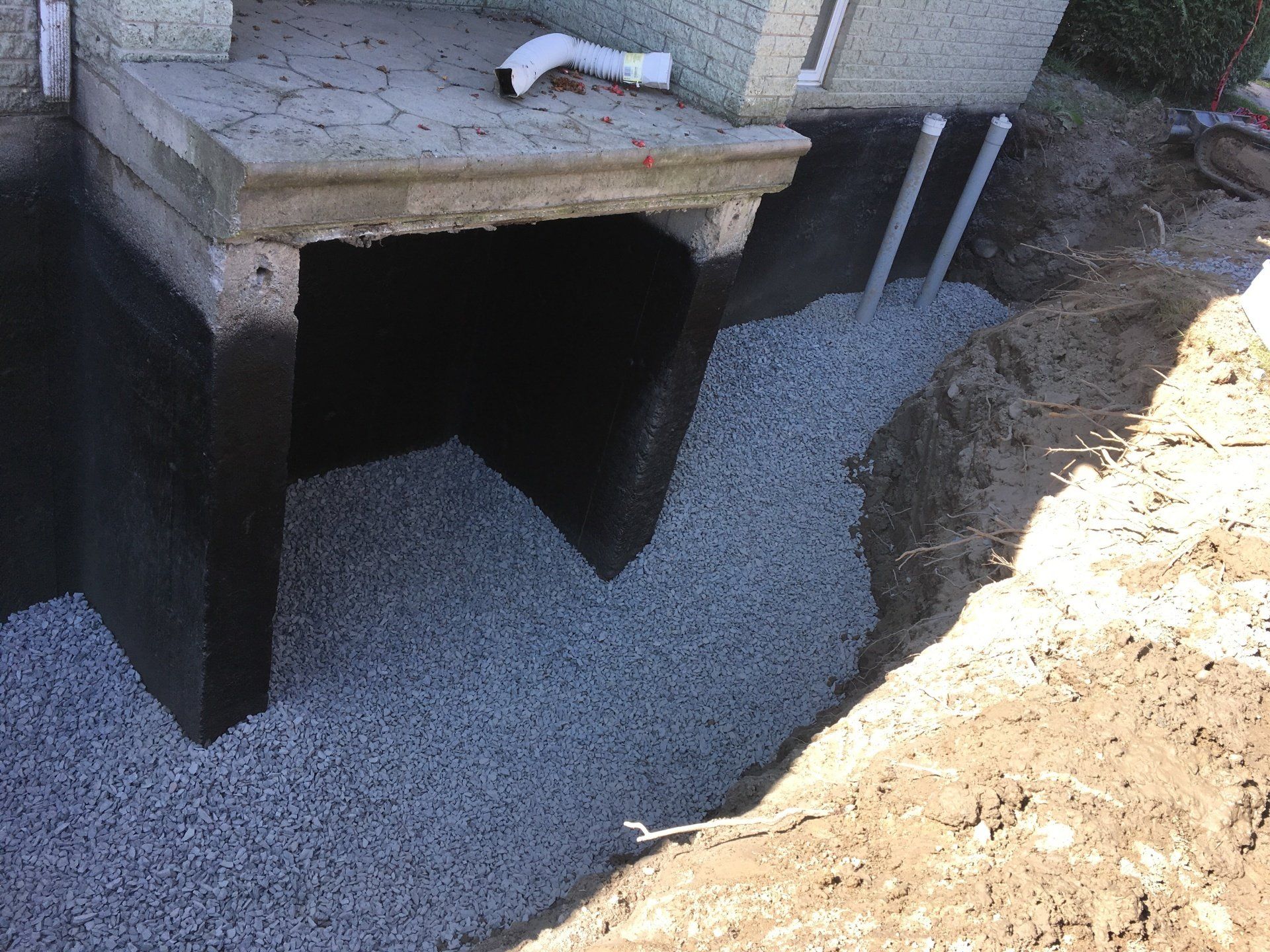 Un système de drainage est en cours d'installation sur le côté d'une maison.