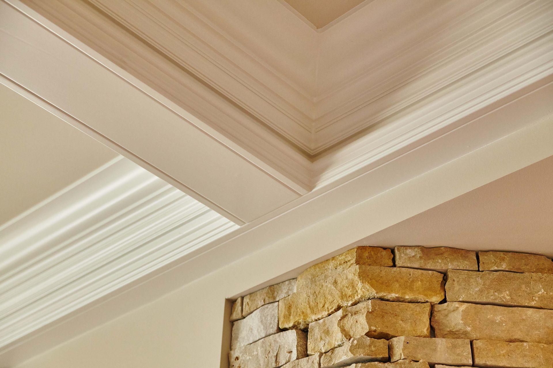 Beige ceiling with white crown molding, adjacent to a tan brick corner.