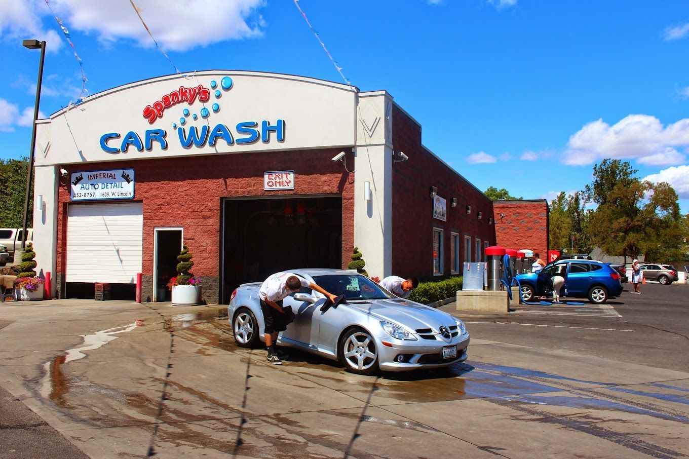 A silver car is being washed at a car wash