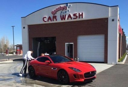 A red Jaguar being cleaned at 