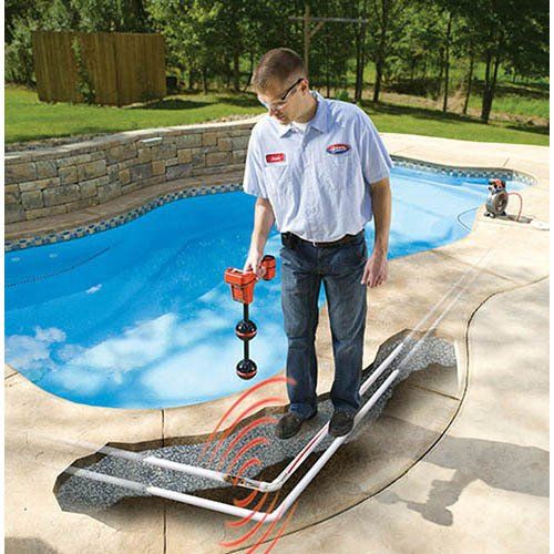 A man standing by a pool holding a Navi Track Scout Rigid pipe locator tool to detect underground utility and pipeing
