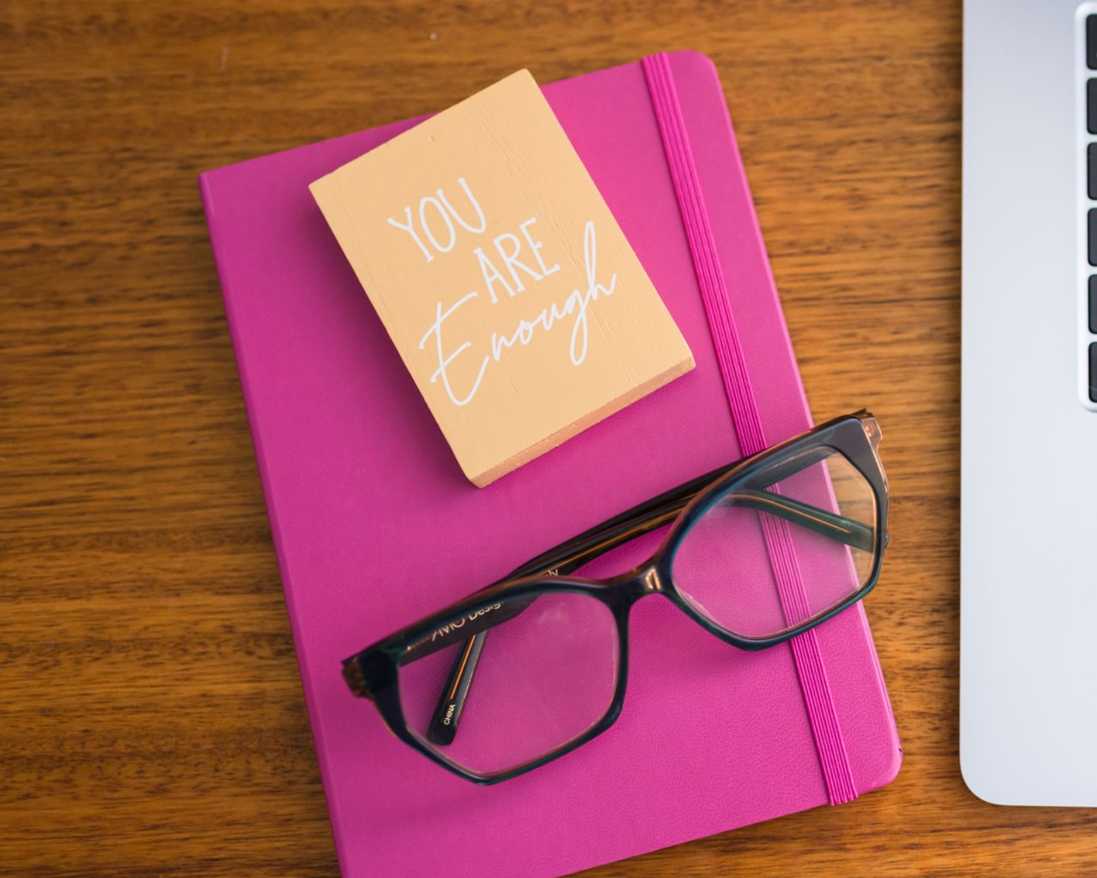 Succulents in a white vase and a sign reading
