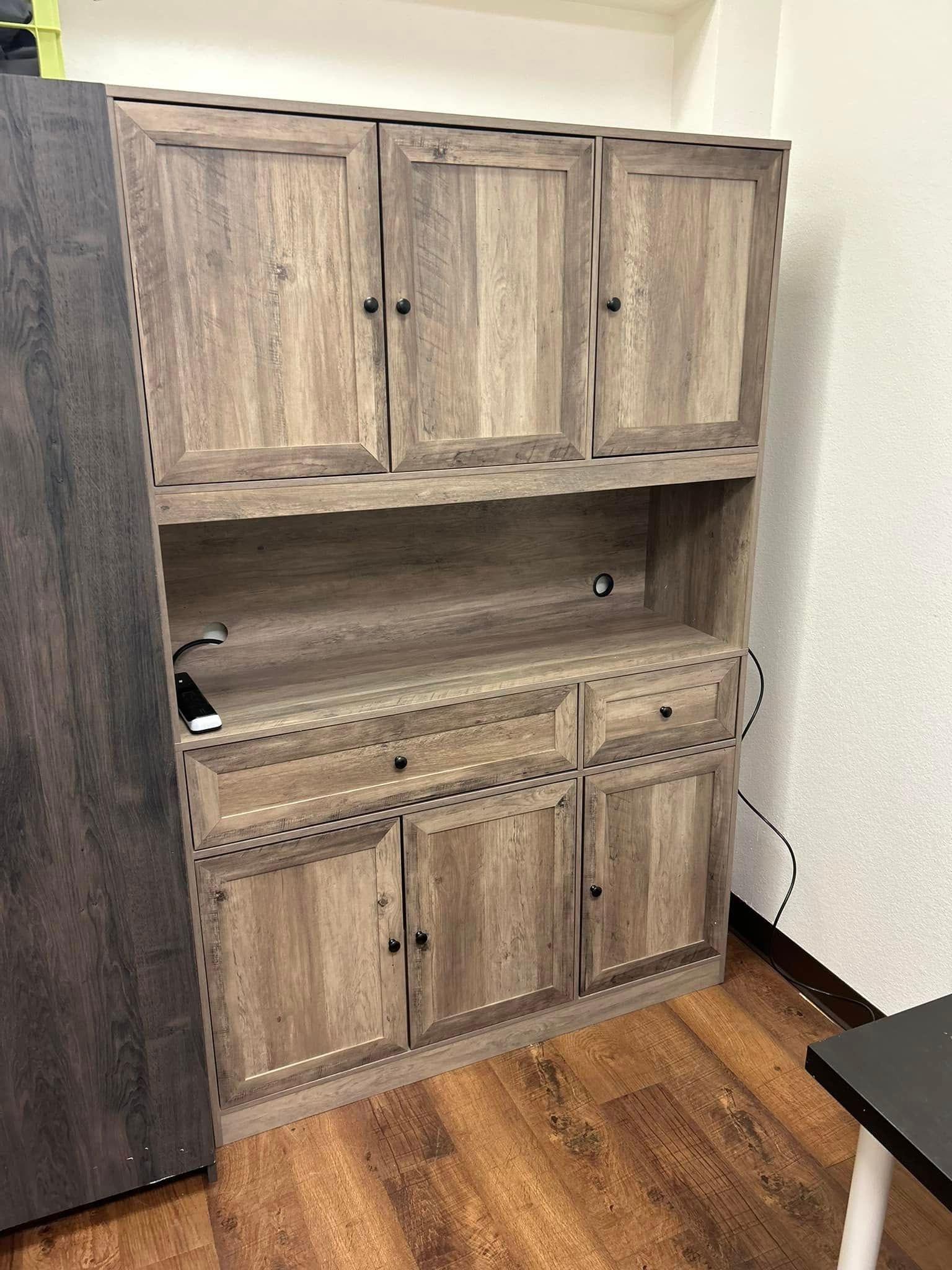 Wooden storage cabinet with multiple doors and drawers.