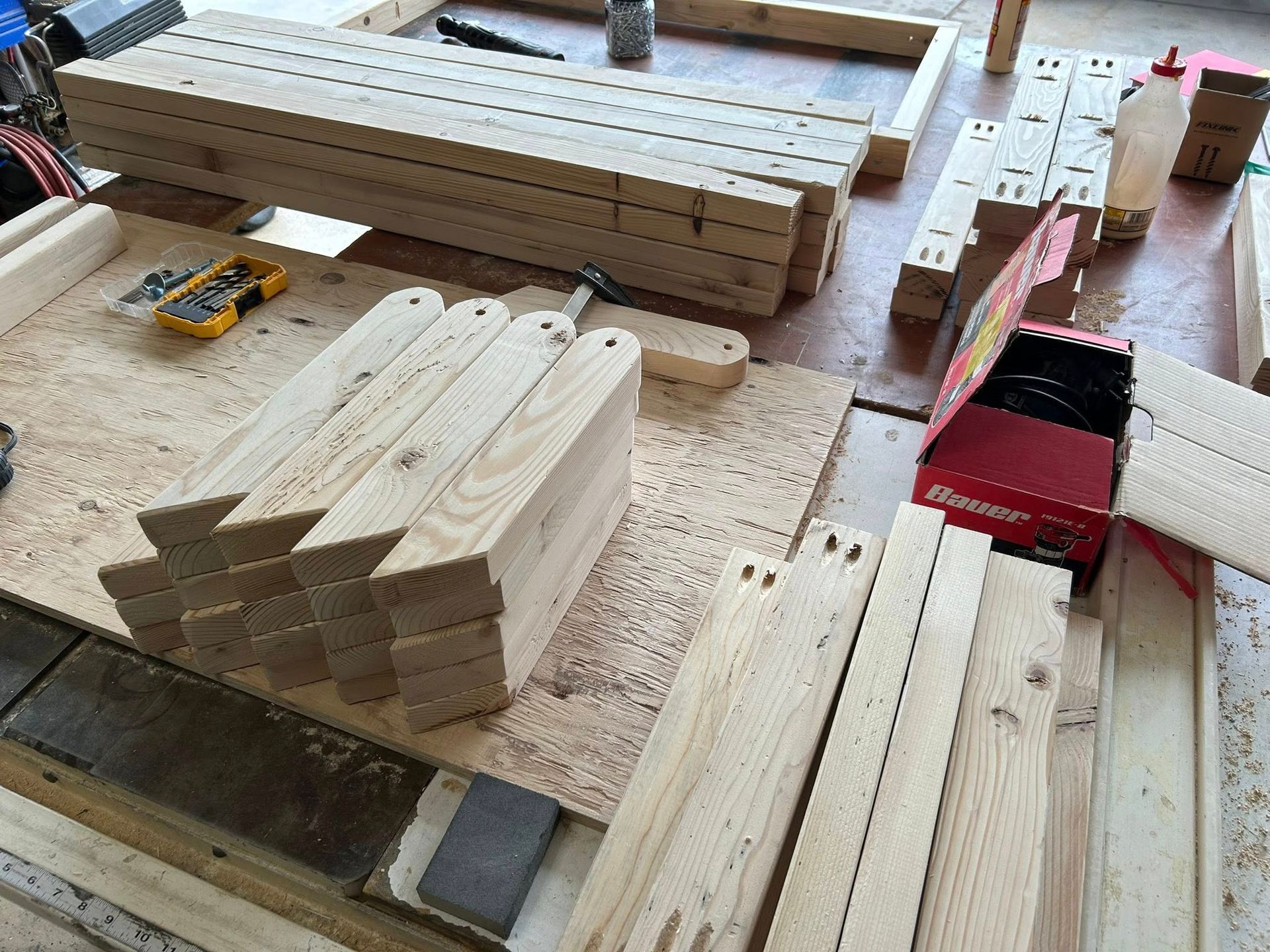 Wooden planks and tools on a workbench, likely for building furniture.