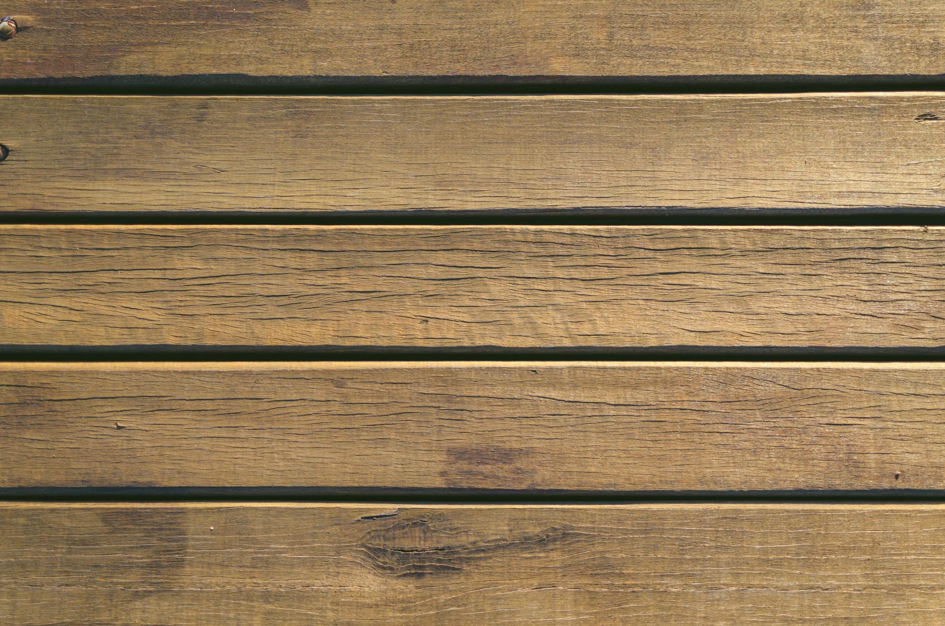 Wooden deck boards, weathered and textured, brown with dark gaps.