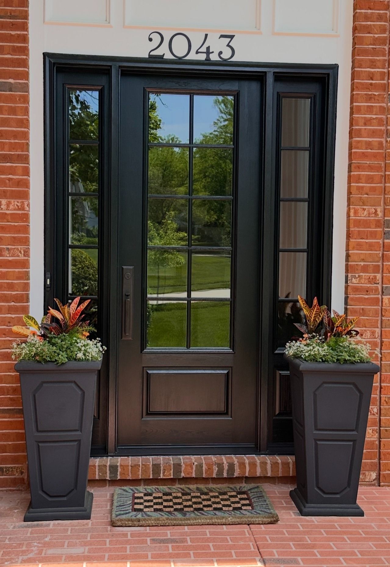 Black front door with sidelights, address