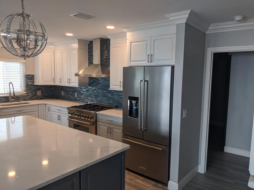 A kitchen with stainless steel appliances and white cabinets.