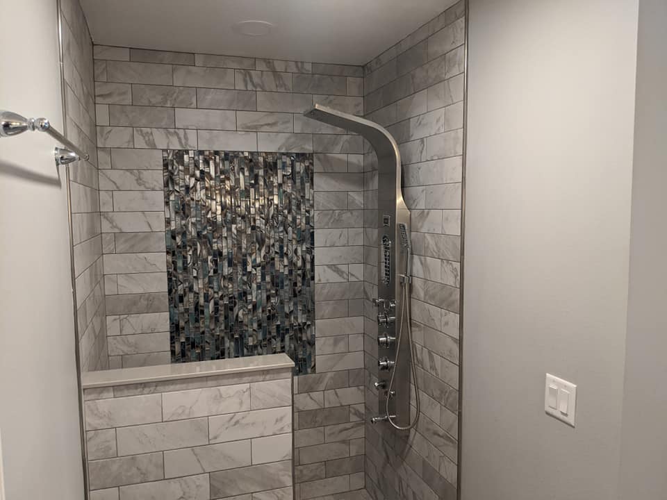 A bathroom with a walk in shower and a shower head.