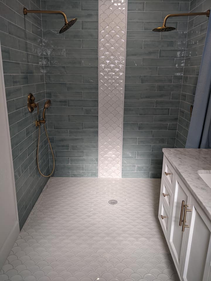 A bathroom with a walk in shower and a sink.