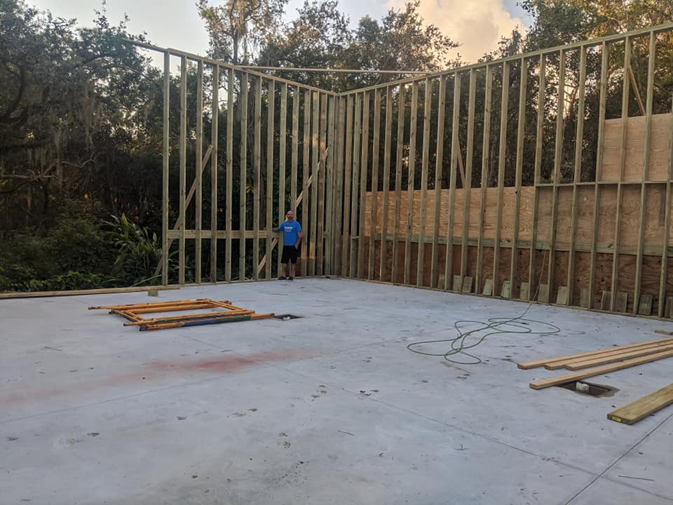 A man is standing in front of a building under construction.