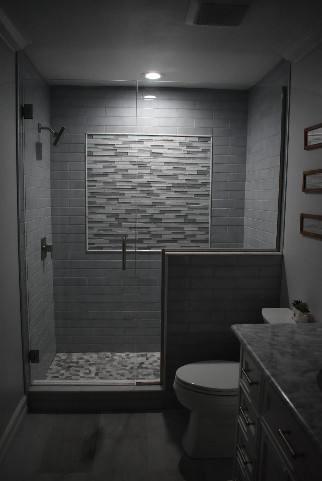 A bathroom with a toilet , shower and mirror.