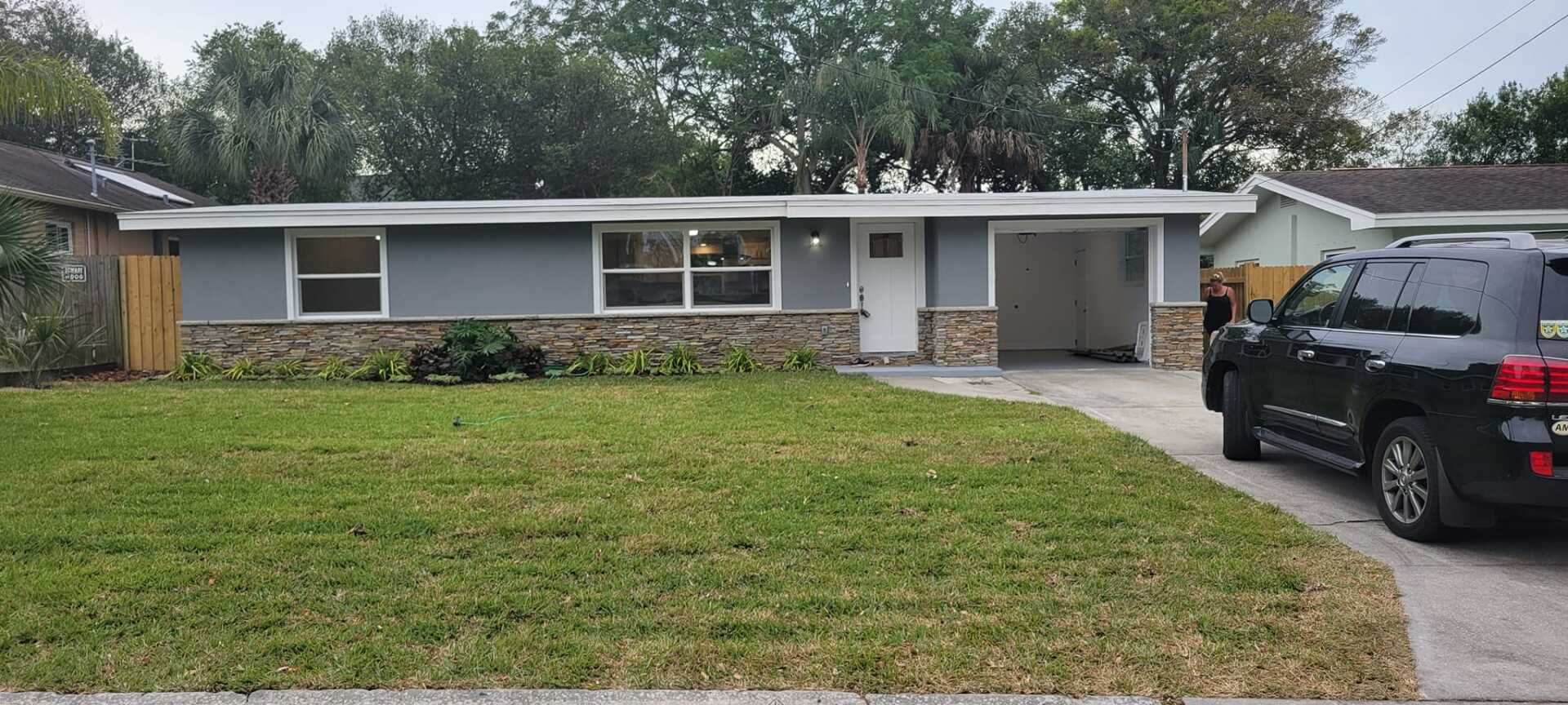 A black suv is parked in front of a house.
