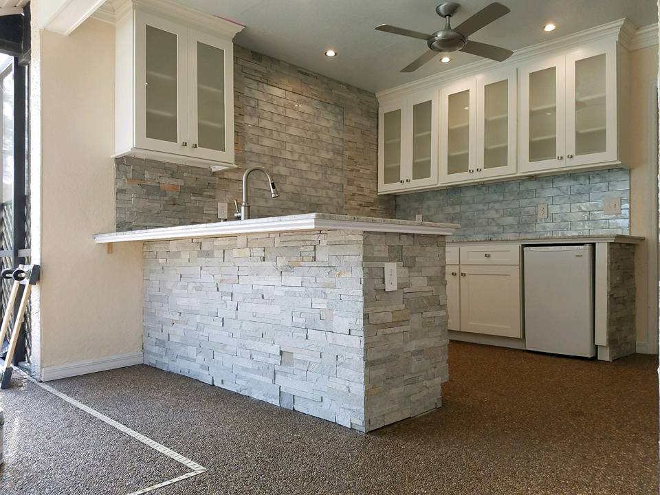 A kitchen with white cabinets and a ceiling fan