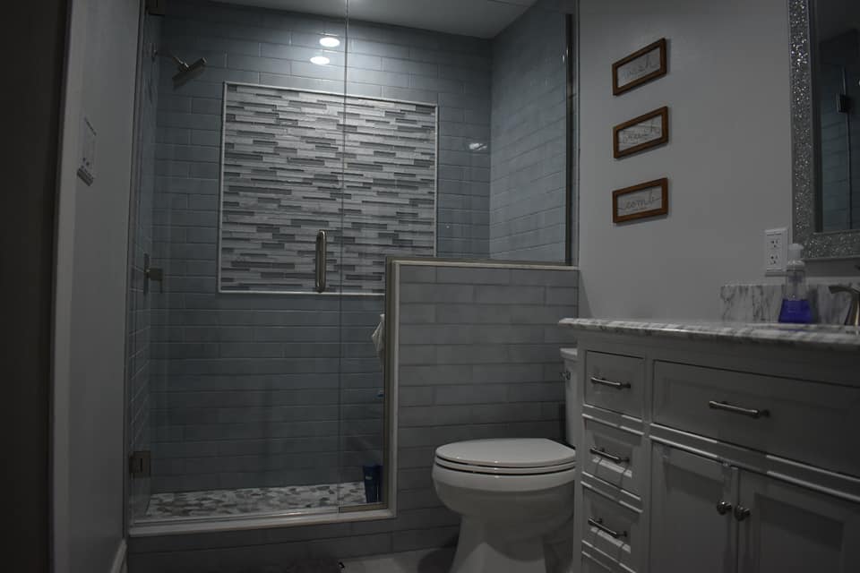 A bathroom with a toilet , sink and shower.