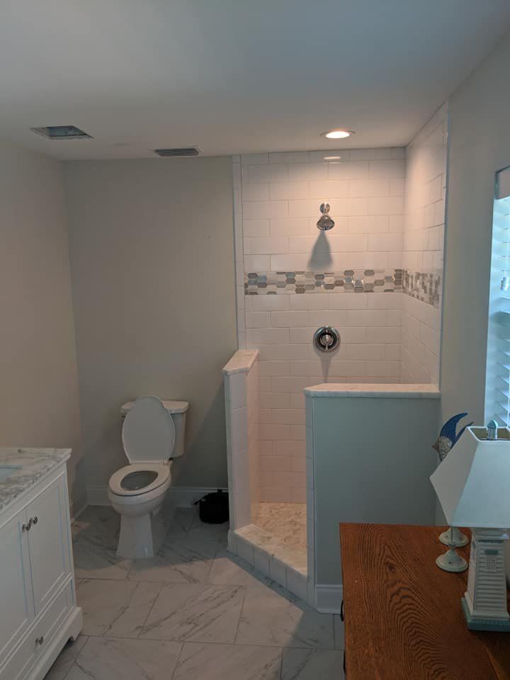 A bathroom with a toilet , sink , and walk in shower.