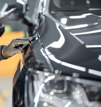 Experts working underneath a car at the auto shop in Hilo, HI
