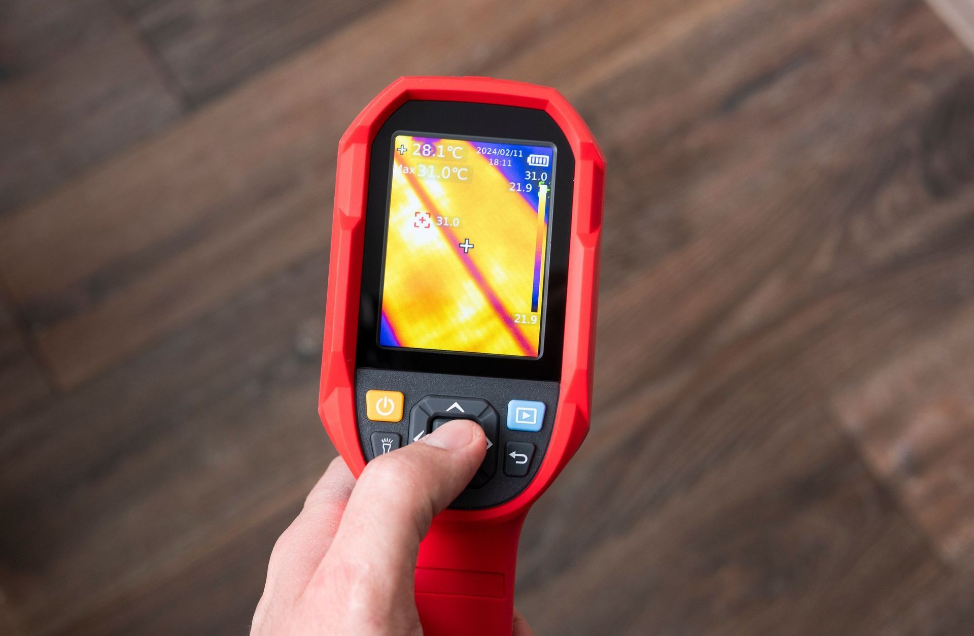 A person is holding a thermal camera in their hand.