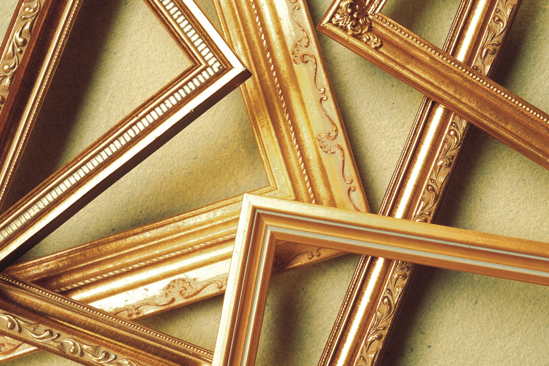 Elegant gold picture frames displayed on textured background for custom framing and home décor