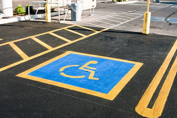 Empty handicap parking space with blue and yellow markings.