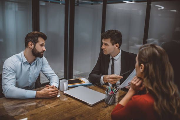 A couple sits with a male attorney discussing divorce, emphasizing the role of a divorce attorney.