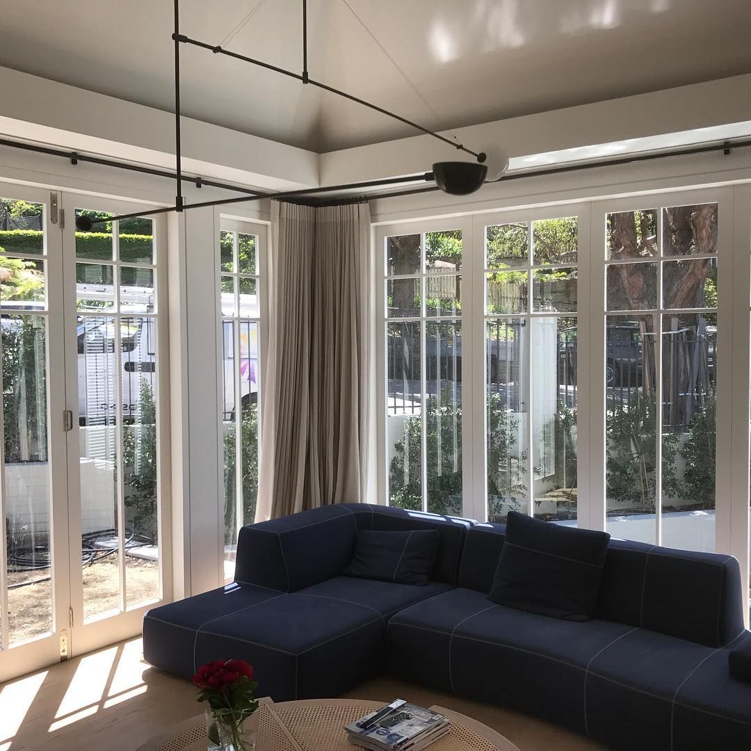 Blue sectional sofa in a sunlit room with French doors.