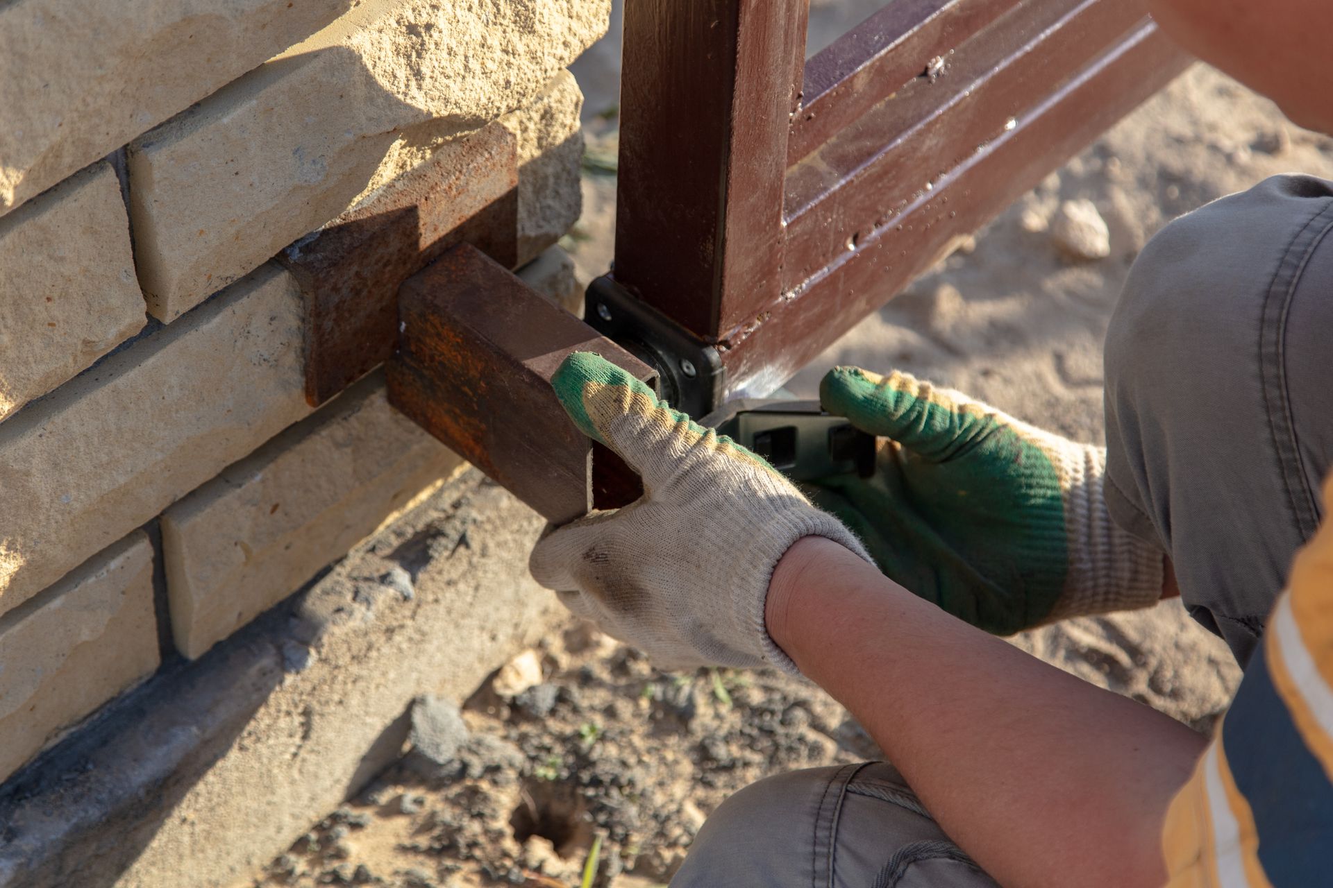 A man is working on a fence with a drill.