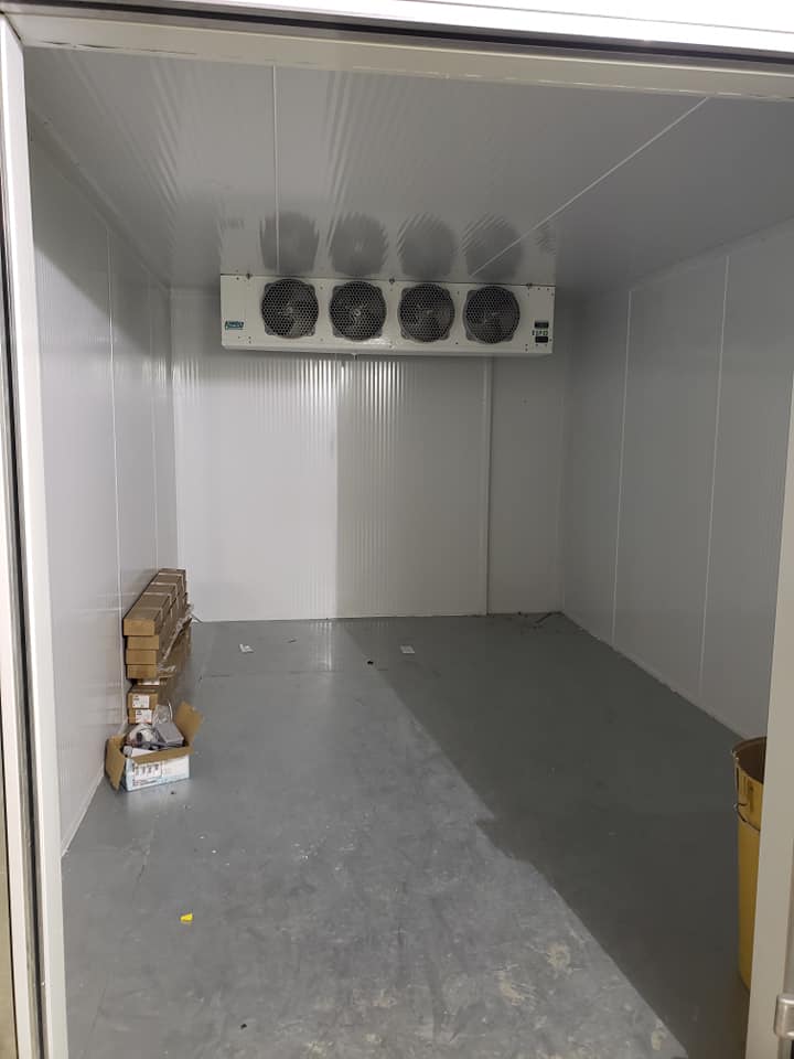 Une grande pièce vide avec beaucoup de ventilateurs au plafond.