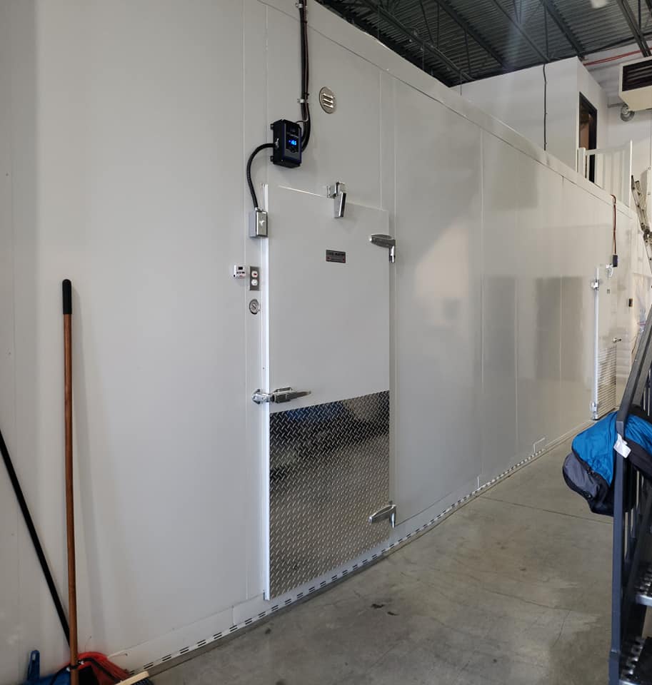 Un grand mur blanc avec une porte dans une pièce.