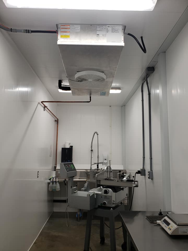 Une cuisine avec un évier et un ventilateur au plafond.