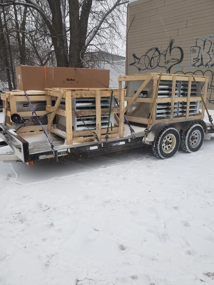 Une remorque avec des caisses en bois est garée dans la neige.